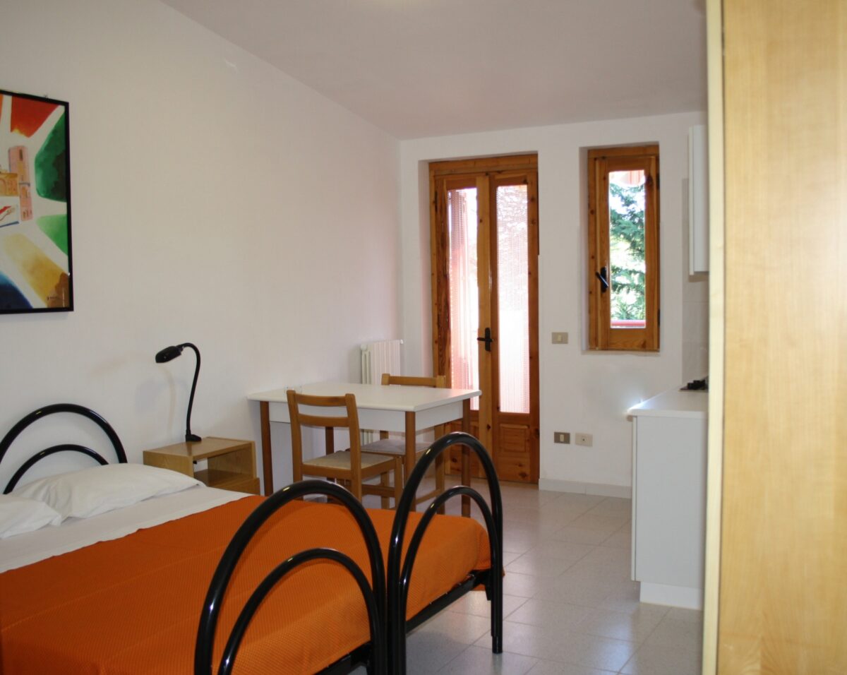 Camera con letto matrimoniale e area pranzo nel monolocale 2/3 persone