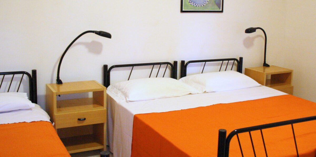 Camera con letto matrimoniale e comodini nel bilocale 3 persone