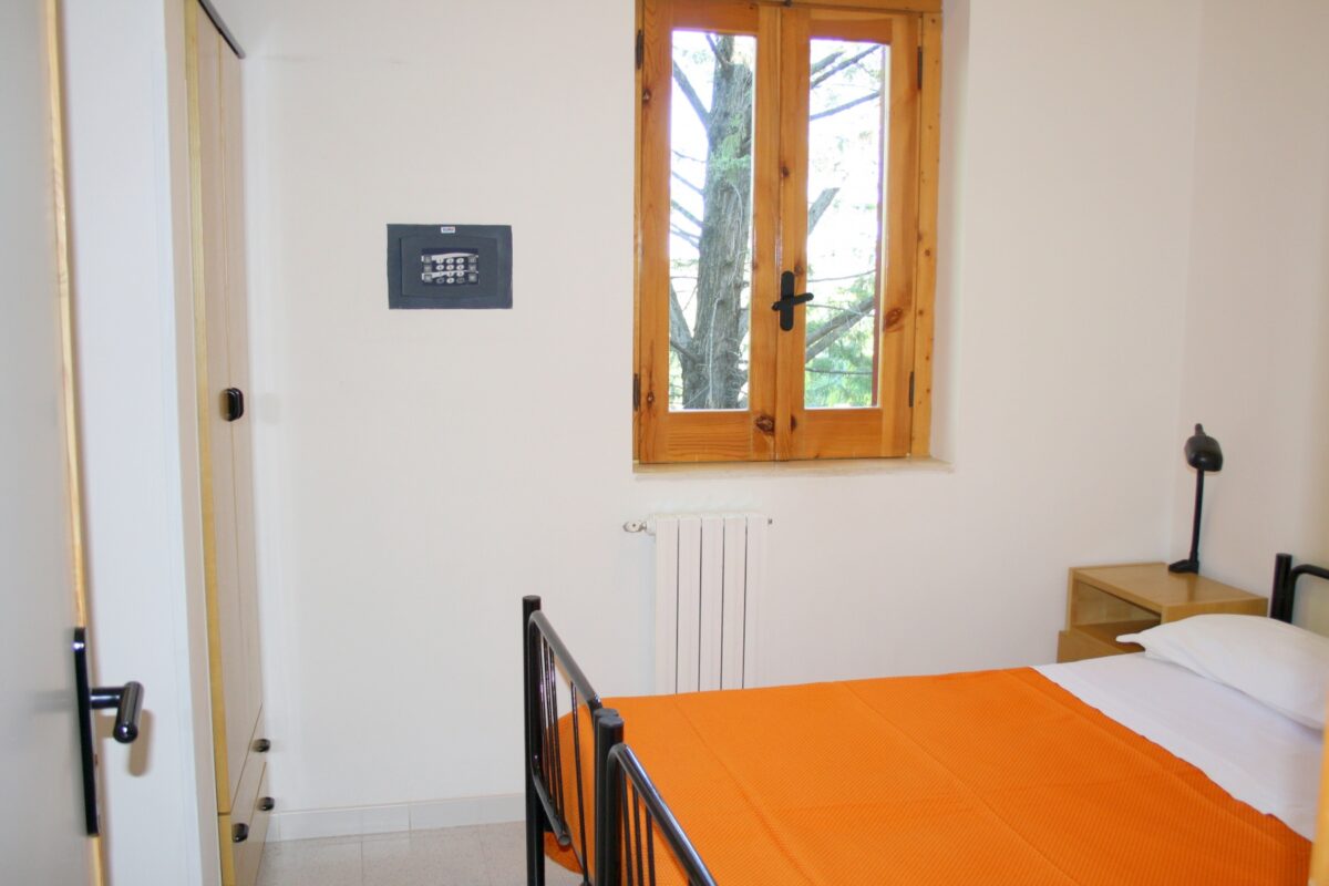 Camera con letto matrimoniale e arredi semplici nel bilocale 3/4 persone
